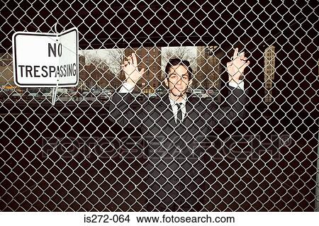 Picture - Businessman trapped behind fence. Fotosearch