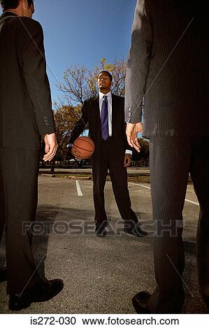 Stock Image - Businessmen on basketball court. Fotosearch