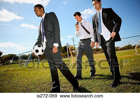 Stock Photo - Businessmen on football pitch. Fotosearch