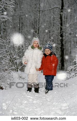 Stock Image - Children standing in a forest. Fotosearch