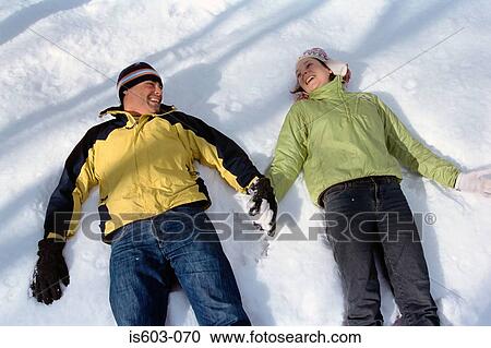 Couple lying in snow View Large Photo Image Stock Image - Couple lying in snow. Fotosearch