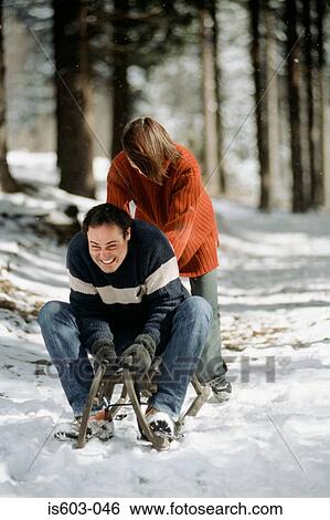 Couple playing on sleigh View Large Photo Image Stock Photograph - Couple playing on sleigh. Fotosearch