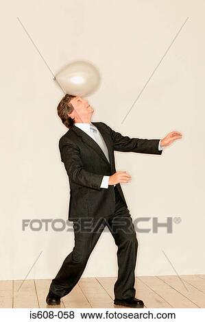 Stock Photo - Man balancing a balloon on head. Fotosearch