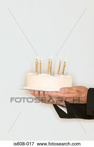 Senior man holding a birthday cake View Large Photo Image Stock Photo - Senior man holding a birthday cake. Fotosearch