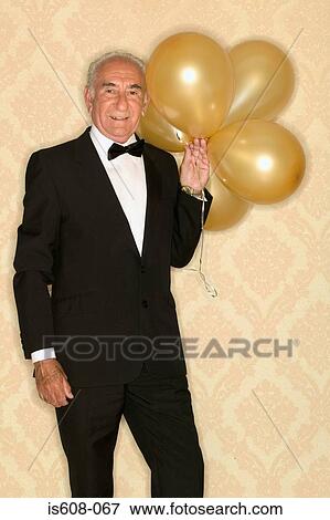 Stock Photo - Senior man holding bunch of balloons. Fotosearch