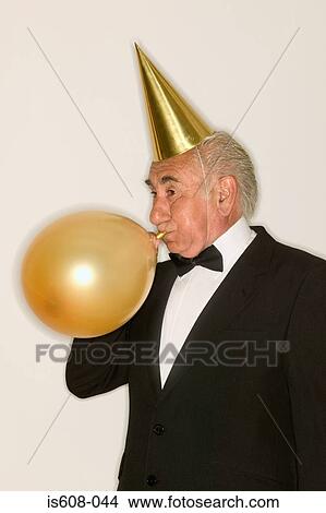 Senior man inflating a balloon View Large Photo Image Picture - Senior man inflating a balloon. Fotosearch