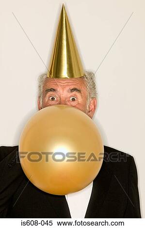 Senior man inflating a balloon View Large Photo Image Stock Photography - Senior man inflating a balloon. Fotosearch