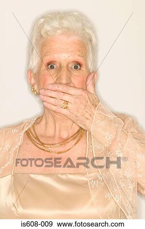Senior woman covering mouth with hand View Large Photo Image Stock Photo - Senior woman covering mouth with hand. Fotosearch