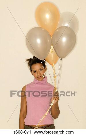 Stock Image - Woman holding a bunch of balloons. Fotosearch