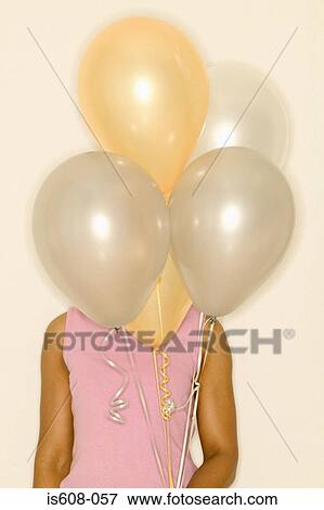 Woman holding a bunch of balloons View Large Photo Image Stock Photo - Woman holding a bunch of balloons. Fotosearch