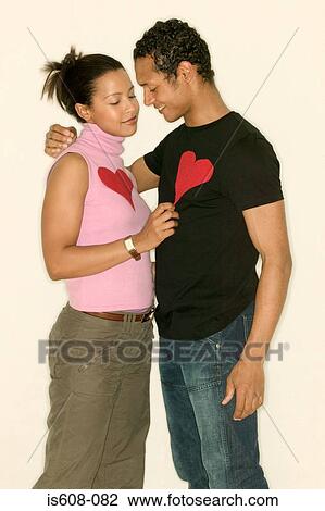 Young couple wearing heart shapes View Large Photo Image Stock Image - Young couple wearing heart shapes. Fotosearch