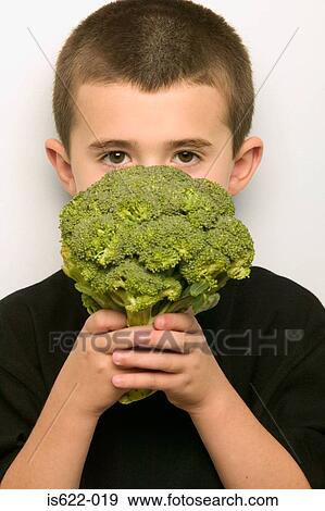 Boy covering face with broccoli View Large Photo Image Stock Photo - Boy covering face with broccoli. Fotosearch
