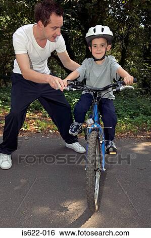 Boy learning to ride a bike View Large Photo Image Stock Photograph - Boy learning to ride a bike. Fotosearch