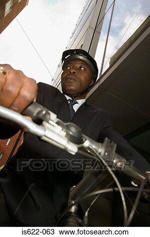 Stock Image - Businessman riding a mountain bike. Fotosearch