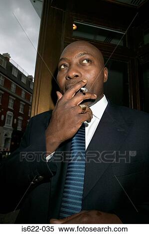 Businessman smoking a cigarette View Large Photo Image Stock Photography - Businessman smoking a cigarette. Fotosearch