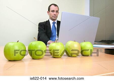 Businessman with apples on desk View Large Photo Image Picture - Businessman with apples on desk. Fotosearch