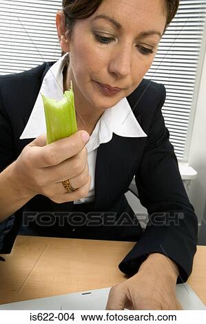 Businesswoman eating celery View Large Photo Image Picture - Businesswoman eating celery. Fotosearch