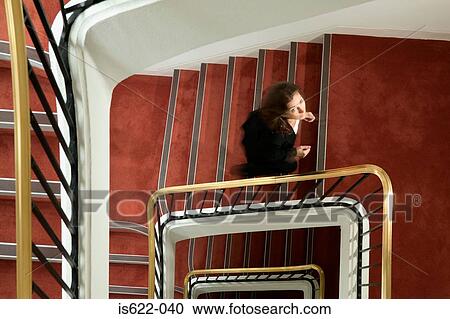 Businesswoman walking up spiral stairway View Large Photo Image Stock Image - Businesswoman walking up spiral stairway. Fotosearch