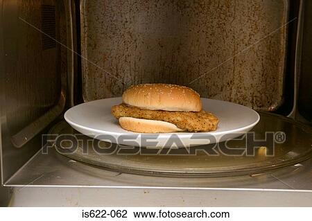 Stock Image - Chicken burger in a microwave. Fotosearch