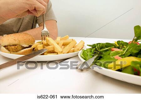 Man eating an unhealthy meal View Large Photo Image Stock Image - Man eating an unhealthy meal. Fotosearch