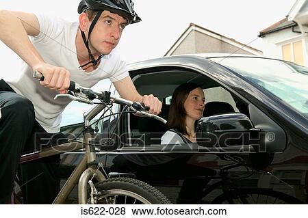 Stock Photo - People travelling by automobile and bicycle. Fotosearch