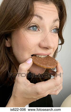 Woman eating a chocolate biscuit View Large Photo Image Stock Photograph - Woman eating a chocolate biscuit. Fotosearch