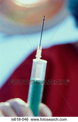Stock Photograph - Anesthetist preparing for injection. Fotosearch