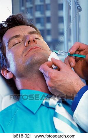 Stock Image - Man having BOTOX ® injections. Fotosearch
