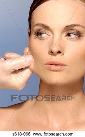 Stock Photograph - Surgeon pulling woman's skin. Fotosearch