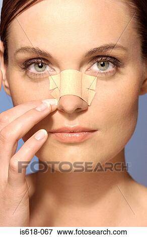 Woman wearing an adhesive plaster on face View Large Photo Image Stock Photo - Woman wearing an adhesive plaster on face. Fotosearch
