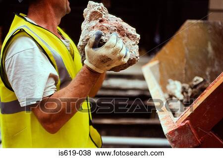 Stock Photo - Construction worker holding rubble. Fotosearch