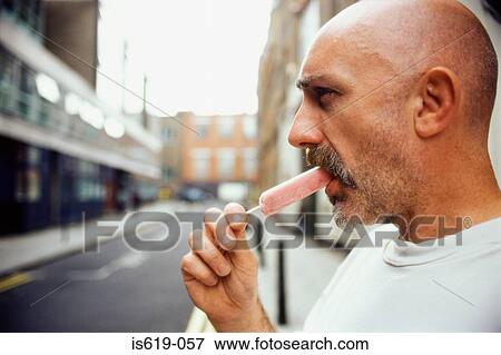 Man eating an ice lolly View Large Photo Image Stock Photo - Man eating an ice lolly. Fotosearch