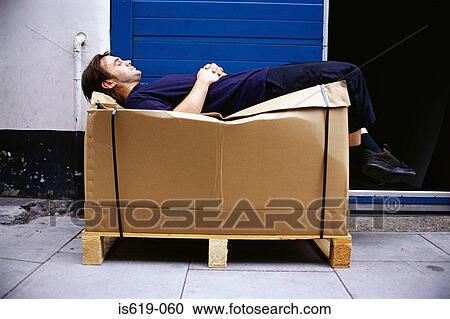 Man resting on cardboard box View Large Photo Image Stock Image - Man resting on cardboard box. Fotosearch