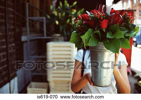Woman holding a bucket of flowers View Large Photo Image Stock Image - Woman holding a bucket of flowers. Fotosearch