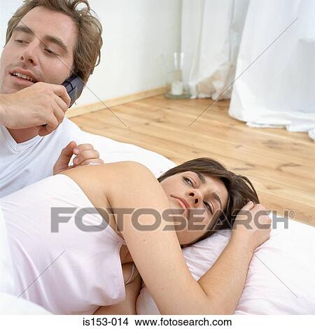 Picture - Couple in bed woken by phone. Fotosearch
