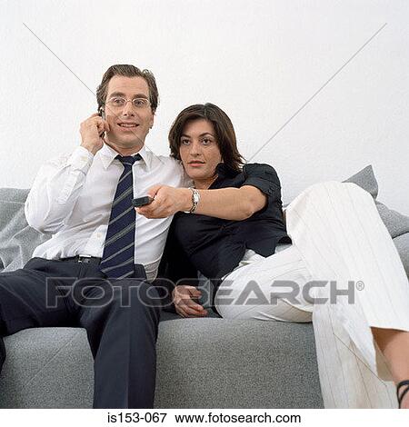 Couple sitting relaxed on sofa View Large Photo Image Stock Photo - Couple sitting relaxed on sofa. Fotosearch
