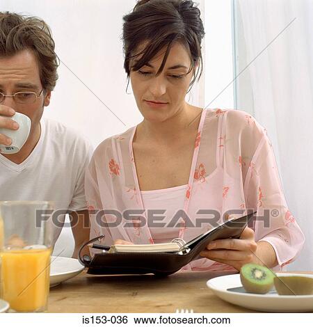 Couple with diary at breakfast View Large Photo Image Stock Photograph - Couple with diary at breakfast. Fotosearch