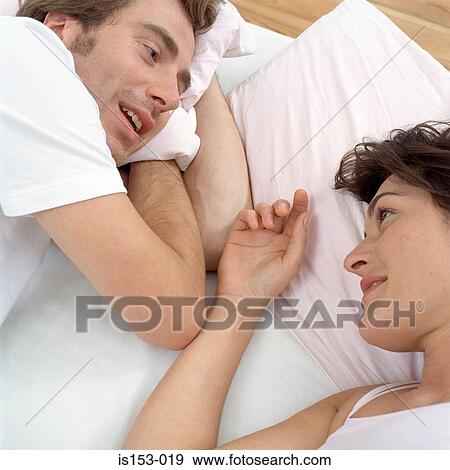 Happy couple awake in bed View Large Photo Image Stock Photo - Happy couple awake in bed. Fotosearch