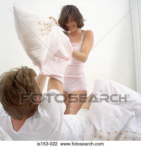 Happy couple in pillow fight View Large Photo Image Stock Image - Happy couple in pillow fight. Fotosearch