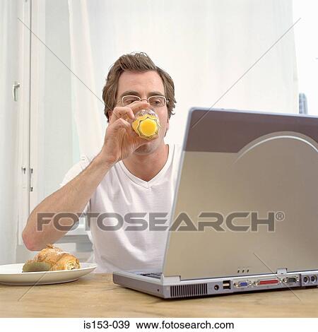 Stock Photo - Man at breakfast with laptop. Fotosearch