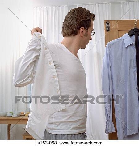 Man getting dressed View Large Photo Image Stock Photo - Man getting dressed. Fotosearch