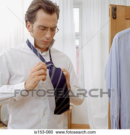 Man getting dressed wears tie View Large Photo Image Stock Image - Man getting dressed wears tie. Fotosearch