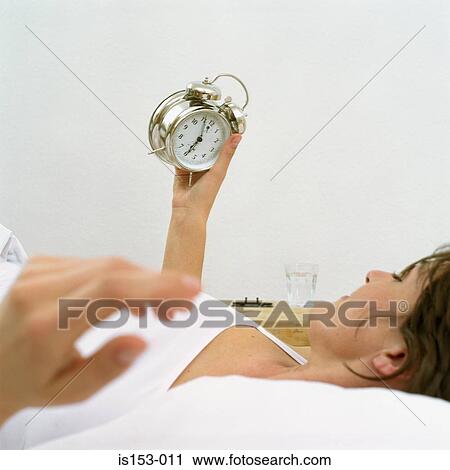 Woman in bed looking at clock View Large Photo Image Stock Image - Woman in bed looking at clock. Fotosearch