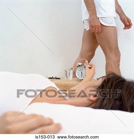 Woman in bed looking at clock View Large Photo Image Stock Image - Woman in bed looking at clock. Fotosearch