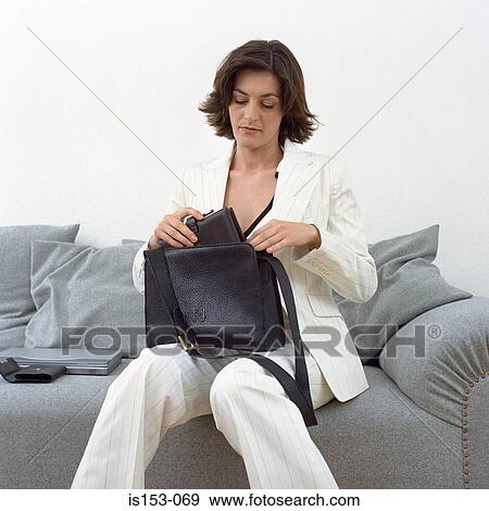 Stock Photo - Woman puts diary in handbag. Fotosearch