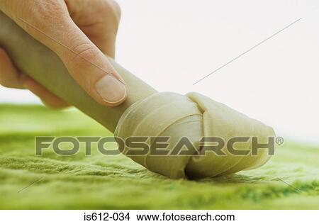Picture - Close-up hand with dog chew. Fotosearch
