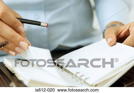 Stock Image - Close-up of hands and diary. Fotosearch