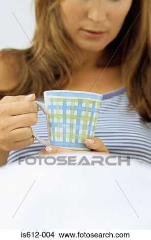 Woman in bed with hot drink View Large Photo Image Picture - Woman in bed with hot drink. Fotosearch