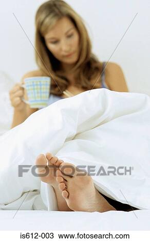 Woman in bed with hot drink View Large Photo Image Stock Image - Woman in bed with hot drink. Fotosearch