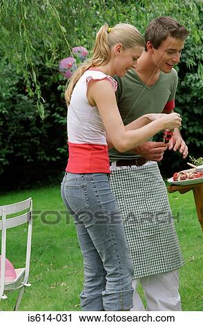 Stock Image - Friends preparing barbeque.. Fotosearch